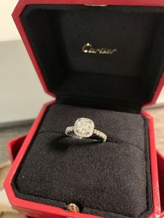 an open red box with a diamond ring in it