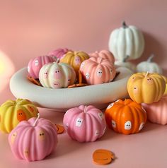 there are many small pumpkins in the bowl and on the table next to each other