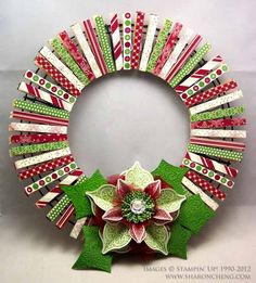 a christmas wreath made out of strips of paper with a poinsettia flower