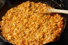 a skillet filled with food and a wooden spoon