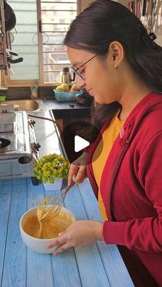 a woman is preparing food in a bowl