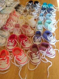 many pairs of baby shoes are lined up on the floor