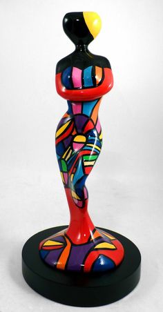 a colorful glass figurine sitting on top of a black base