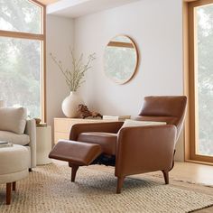 a living room with two chairs and a round mirror