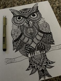 an owl sitting on top of a tree branch next to a marker and some pens