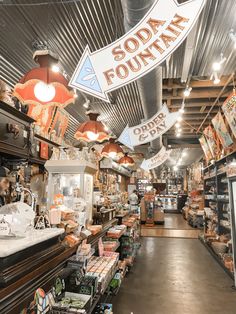 the inside of a store with lots of items on display and signs hanging from the ceiling