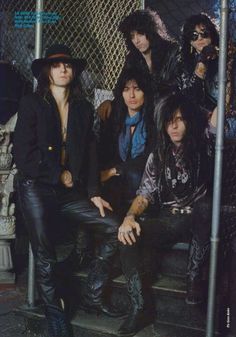 the band kiss posing for a photo in front of a fence