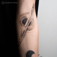 a person with a black and white tattoo on their arm that has an image of the solar system