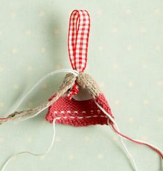 an ornament hanging from a string on top of a green surface with polka dots