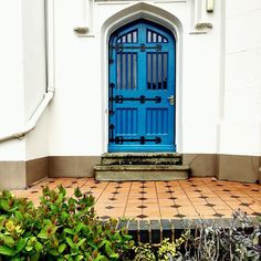 a blue door sits in front of a white building