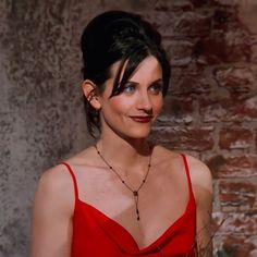 a woman in a red dress is smiling at the camera