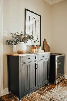 an entryway with a cabinet, mirror and vase on the sideboard in front of it