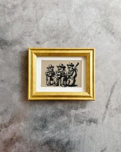 a framed drawing of three people sitting on a bench in front of a stone wall