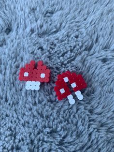 two red and white legos laying on top of a gray carpet