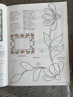 an open book with flowers and leaves on it's page, showing the inside pages