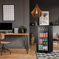 a mini fridge sitting on top of a hard wood floor next to a computer desk