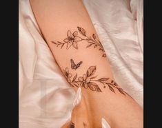 a woman's arm with flowers and butterflies on it