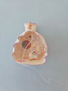 a ceramic figurine is hanging on the wall in front of a blue background