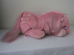 a pink stuffed animal laying on top of a white table