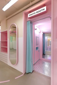 a pink and blue photo booth with mirrors on the wall next to it's doors