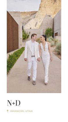 a man and woman walking down a sidewalk holding hands