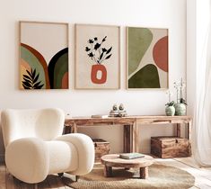 three paintings hang on the wall above a white chair and coffee table in a living room