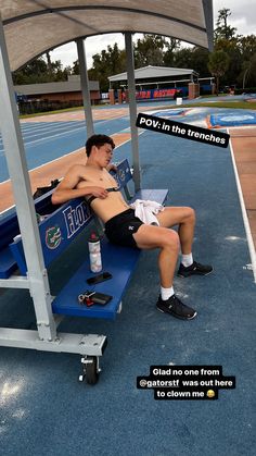 a man sitting on top of a blue bench