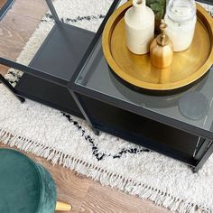 a coffee table with two vases on it and a glass top in the middle