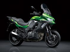 a green and black motorcycle parked in the dark