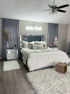 a bedroom with a large bed and white rugs