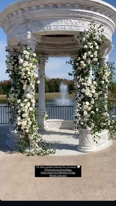 a white gazebo covered in flowers and greenery