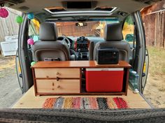 the back end of a van with an entertainment center in the passenger side door area