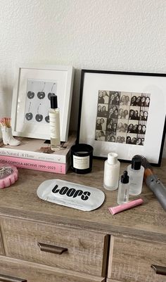 a dresser with some personal care items on top of it next to a framed photo