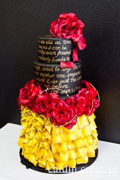 a multi - tiered cake with roses on top is decorated in black, yellow and red