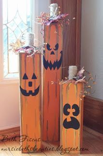 three wooden pumpkins with faces painted on them are sitting in front of a window