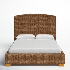 a wicker bed with white pillows on it