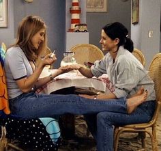 two women sitting at a table talking to each other