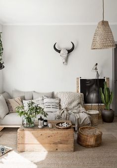 a living room filled with lots of furniture next to a wall mounted deer head on the wall