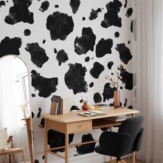 a black and white cow print wallpaper in a home office with a wooden desk