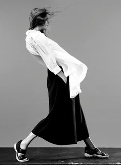 black and white photograph of woman in dress walking