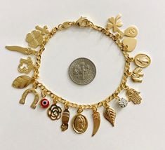 "18k gold filled charm (virgin mary,elephant,evil eye,hamsa,money bag,heart,crystal ,horseshoe cross)bracelet for good luck and protection..7.5\" long . pulsera de buena suerte en18k gold filled. para proteccion y buena suerte.7.5\" largo." Spiritual Yellow Gold Charm Bracelet, Gold Spiritual Rosary Bracelet With Charms, Spiritual Gold Rosary Bracelet With Charms, Gold Charm Bracelet With Symbolic Dangling Charms, Gold Spiritual Charm Bracelet With Dangling Charms, Nickel-free Gold Spiritual Charm Bracelet, Gold Nickel-free Spiritual Charm Bracelet, Gold Spiritual Charm Bracelet With Lobster Clasp, Handmade Symbolic Gold Charm Bracelet