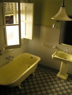 a yellow bath tub sitting next to a white sink in a bathroom under a window