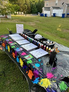 the table is covered with art supplies and has been set up for an outdoor event