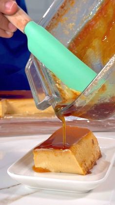 someone pouring caramel sauce on a piece of cheesecake