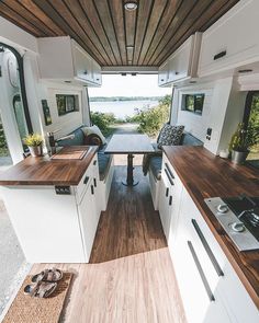 the interior of a camper with wood flooring and white cabinets is seen in this image