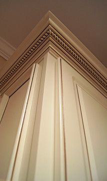 the corner of a kitchen cabinet with molding on it's sides and bottom