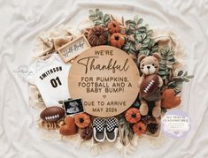 a baby announcement with teddy bears, footballs and pumpkins in the center on a blanket