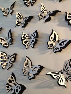 a group of butterflies that are on the wall in front of a mirror with black and white designs