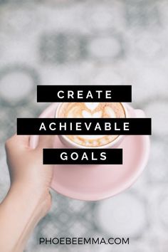 a person holding a cup of coffee with the words create achieve goals on top of it