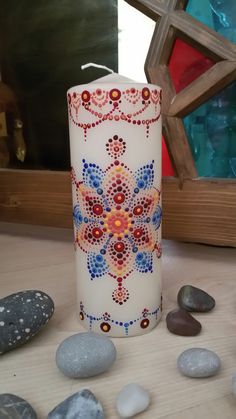 a candle sitting on top of a table next to rocks